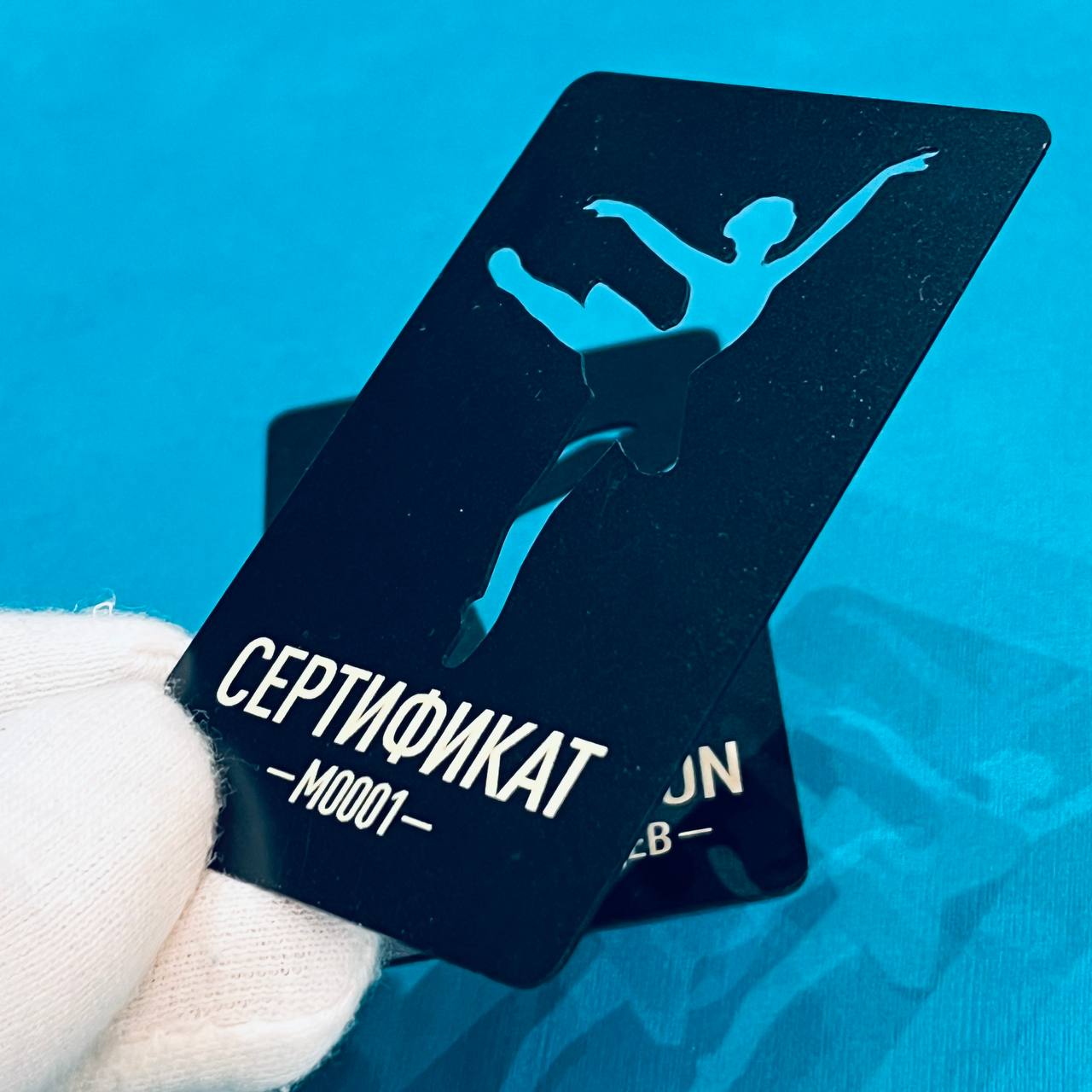 Подарочный сертификат для студии танцев на чёрном пластике в массе с фигурной вырубкой логотипа. УФ-печать с двух сторон.