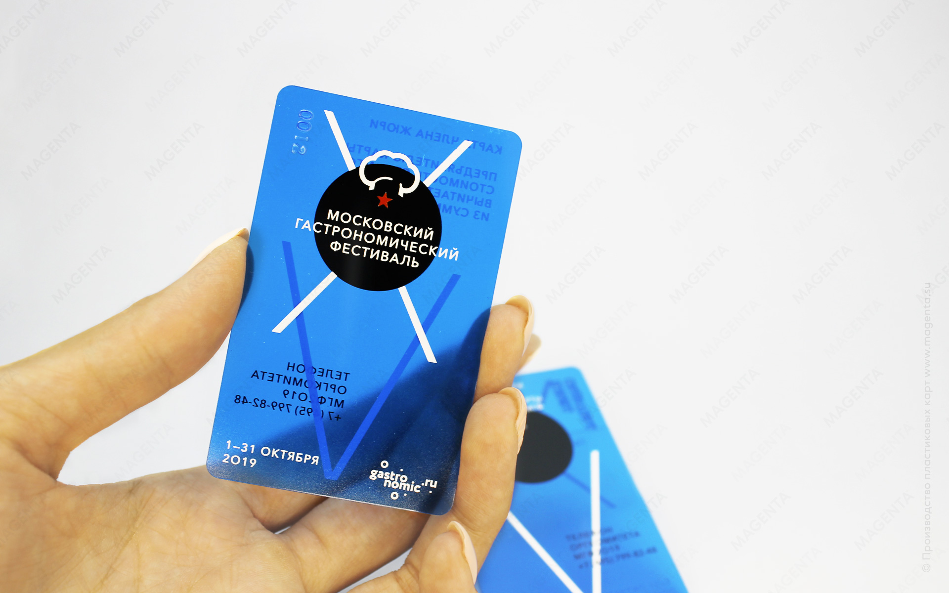 Прозрачная пластиковая карта синего цвета в руке девушки