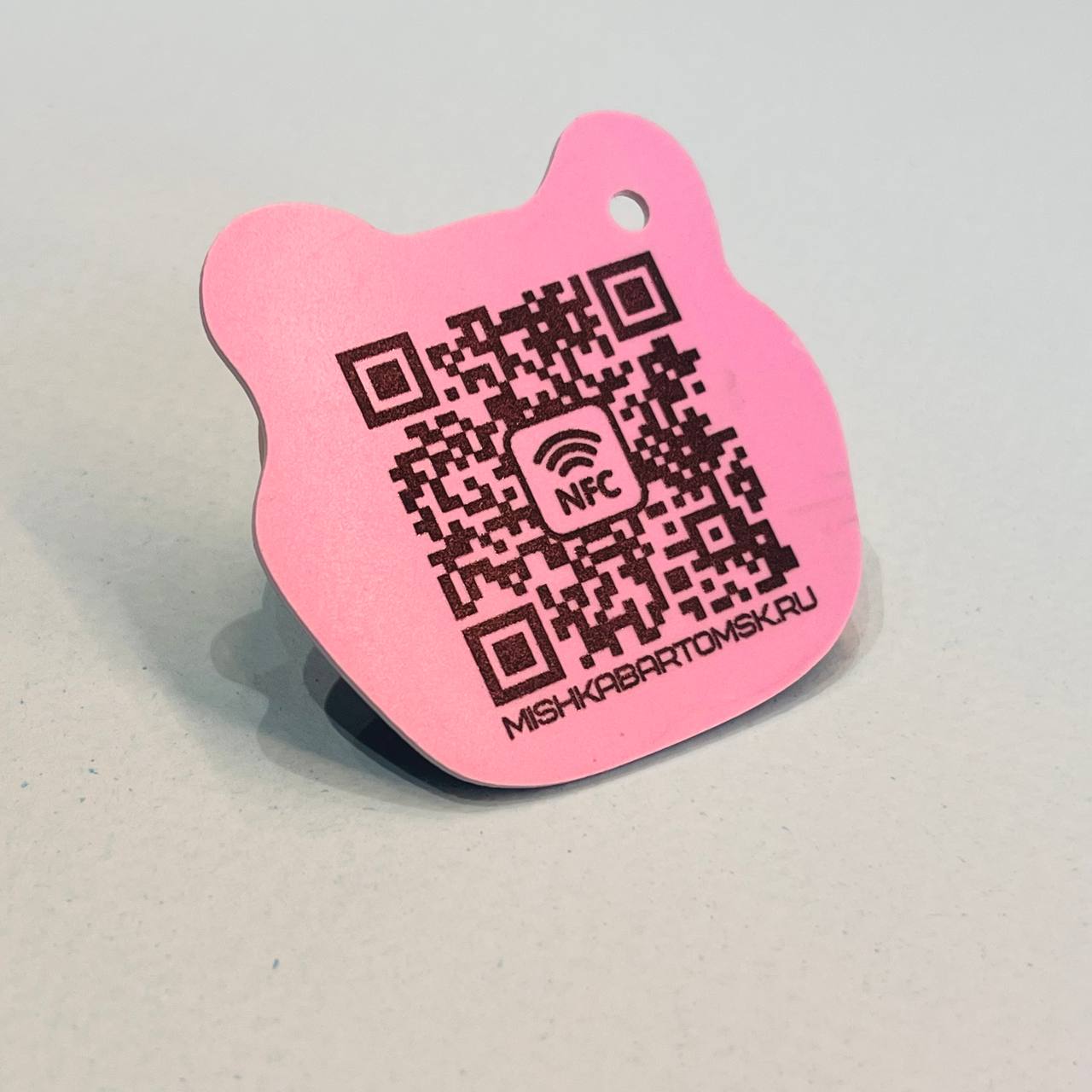 NFC-метка с QR-кодом на пластике нестандартной формы NFC-брелок с QR-кодом на обороте — ссылка на промо-страницу вшита и в чип и в QR. Нестандартная форма вырубки. МАДЖЕНТА.