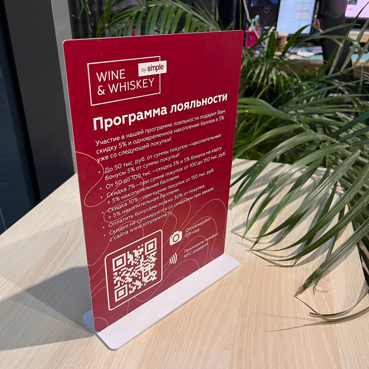 Изображение фронтальной стороны NFC-таблички с логотипом и призывом к регистрации в программе лояльности.